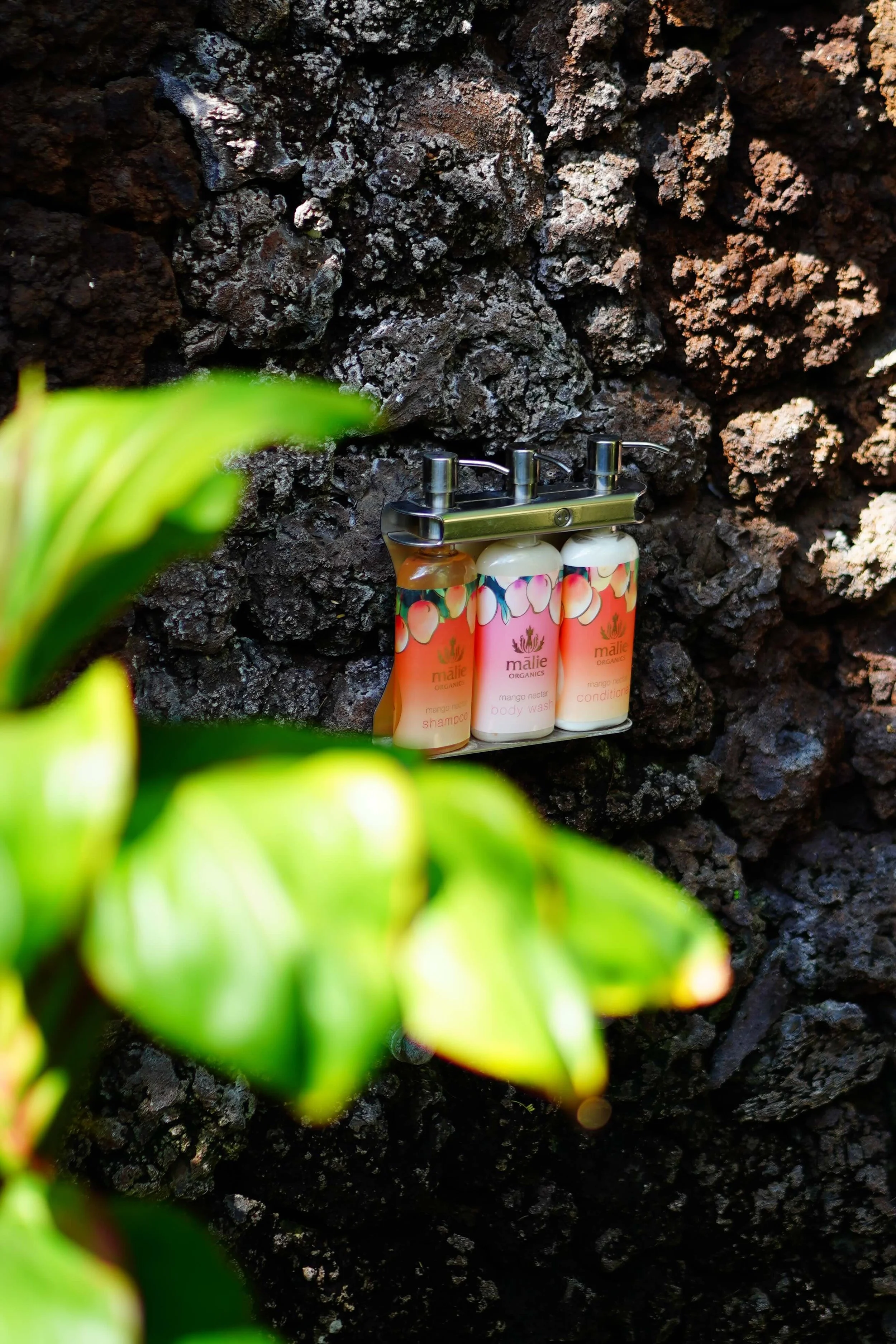 Hawaii-made bath products on the outdoor shower rock wall